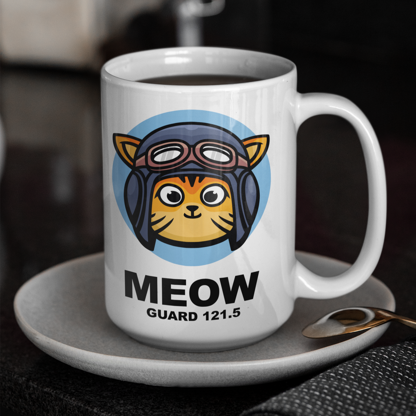 White mug on saucer with cartoon aviator cat with Meow Guard 121.5 text