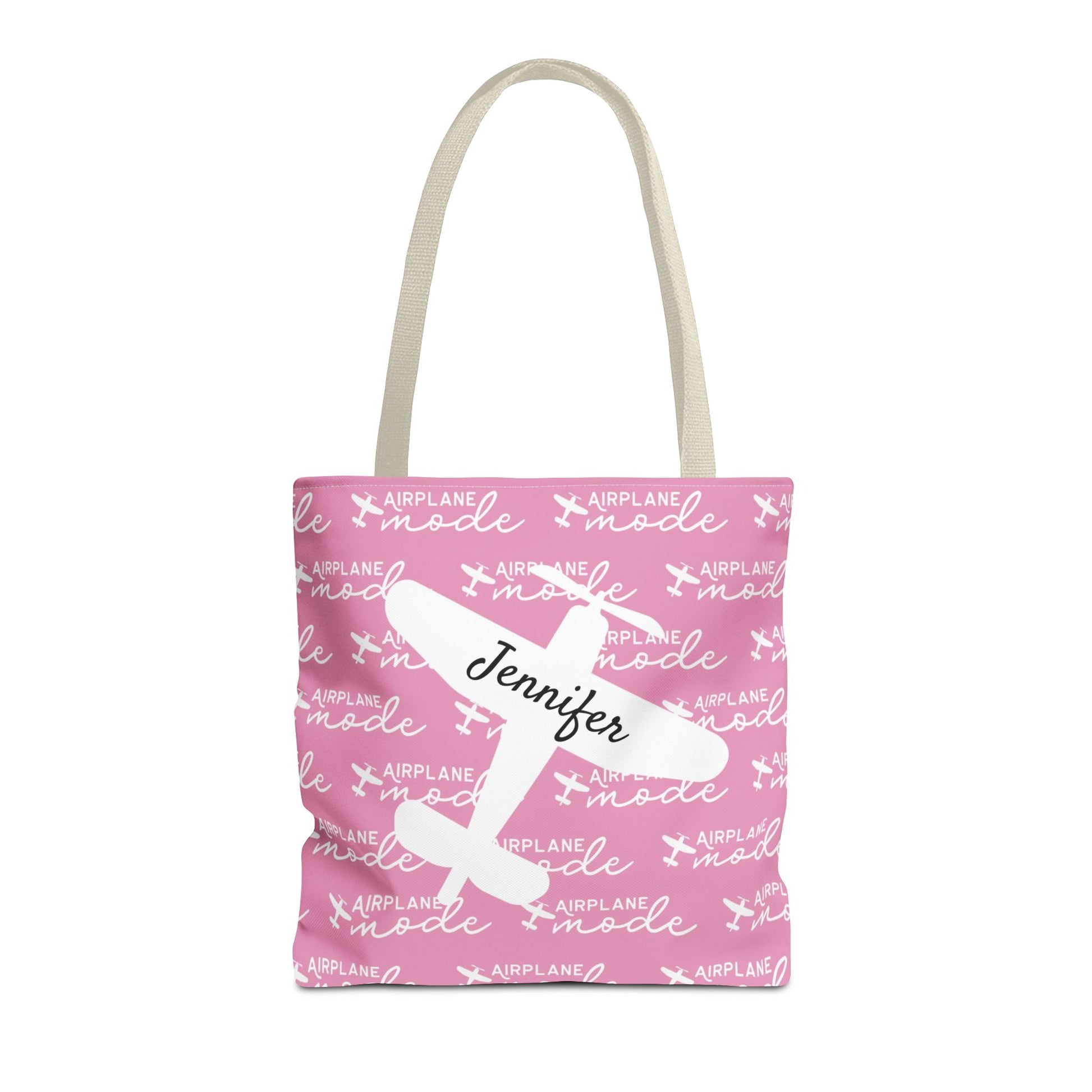 Pink tote bag with airplane mode text and a name on a white background