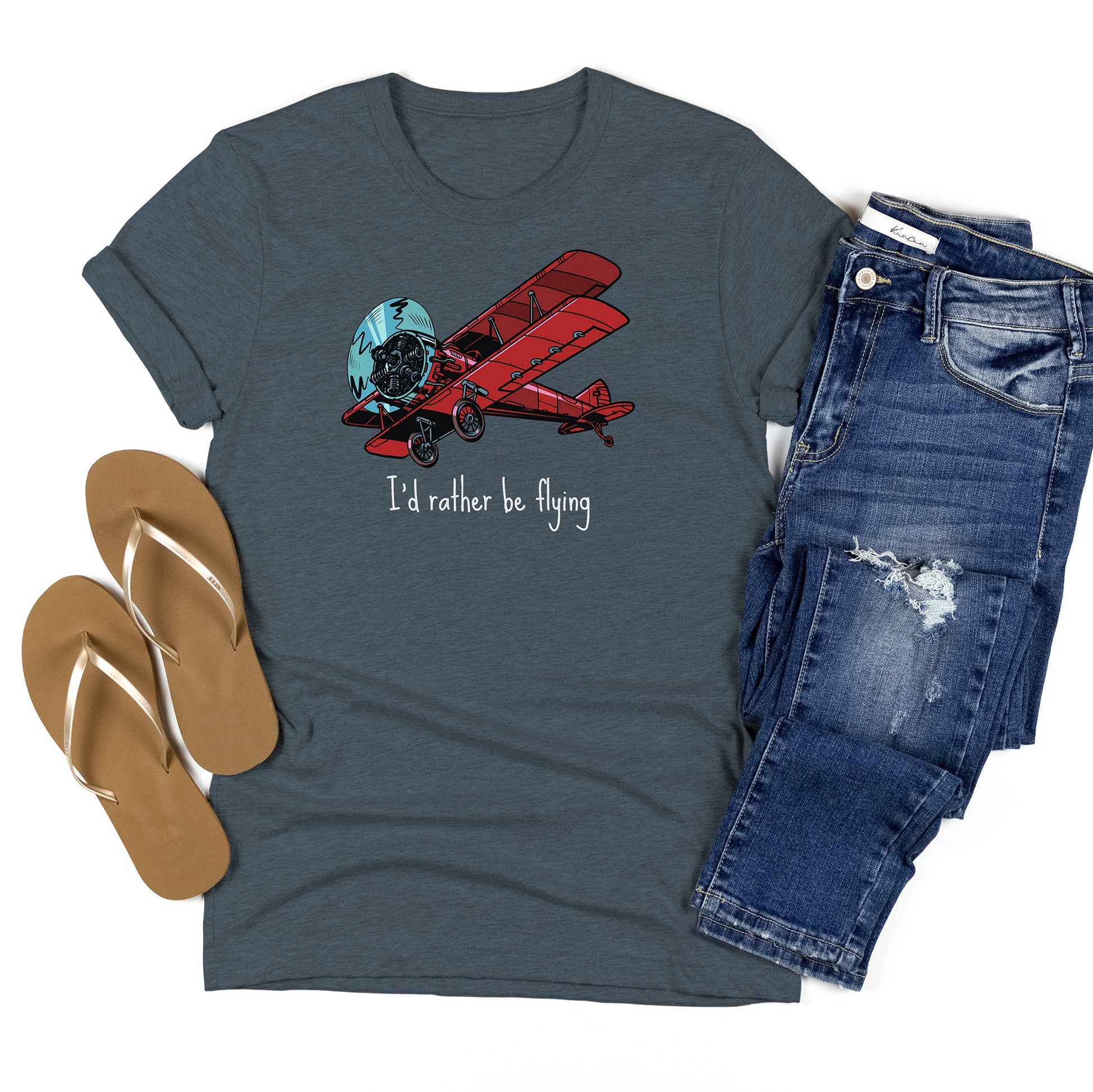 Indigo t-shirt flatlay with a large red biplane and text stating I'd rather be flying underneath