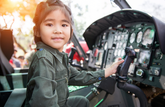 Small girl at controls of helicopter. Shutterstock