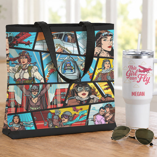 A canvas tote bag with a colorful comic book panel print featuring aviator characters, displayed on a wooden table next to a white insulated tumbler and sunglasses.
