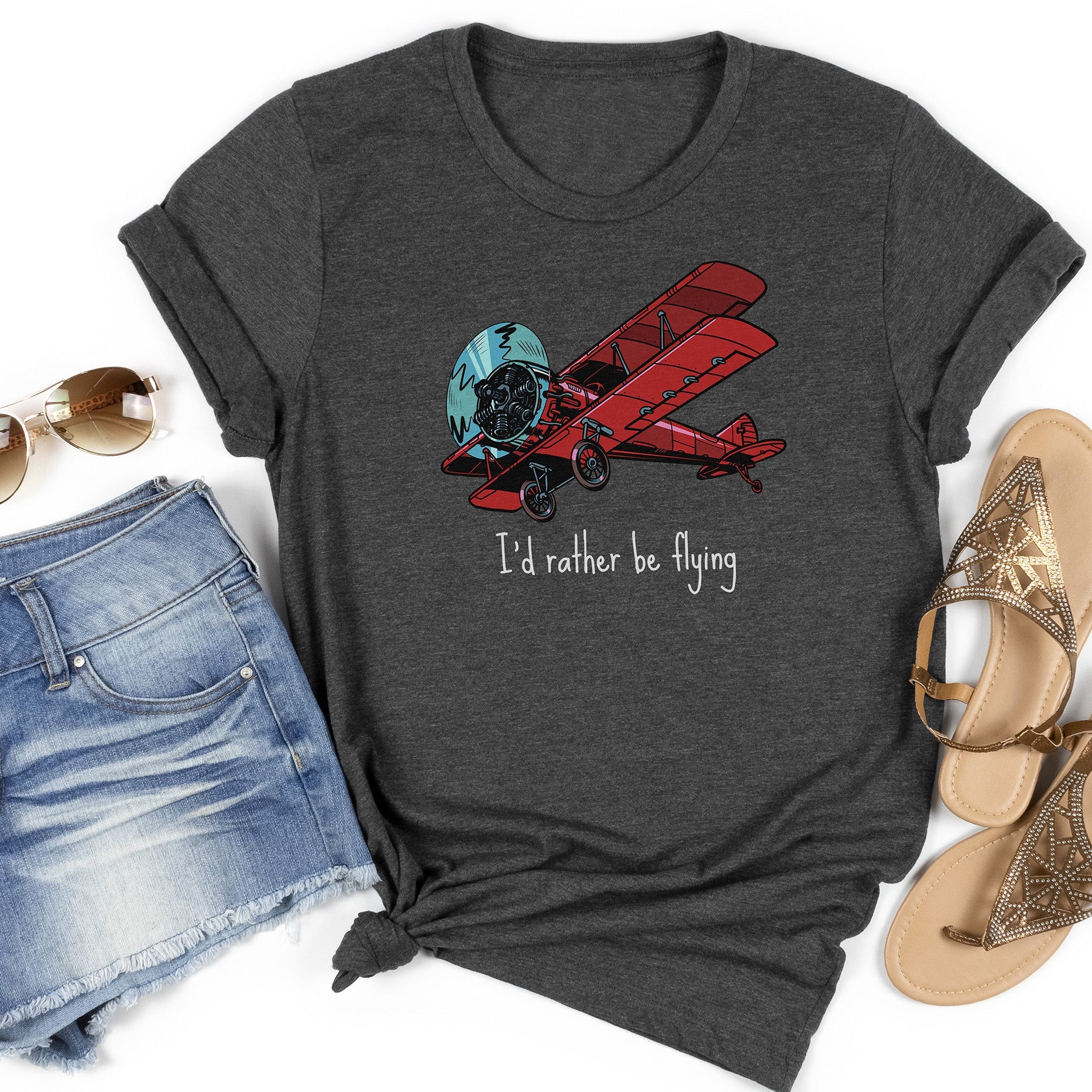 Dark gray t-shirt flatlay with a large red biplane and text stating I'd rather be flying underneath